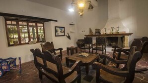 Habitación tradicional con muebles de madera, un tablero de ajedrez y una chimenea.