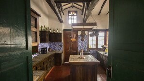 Una cocina rústica con armarios de madera, una isla central y un ventanal con vistas.