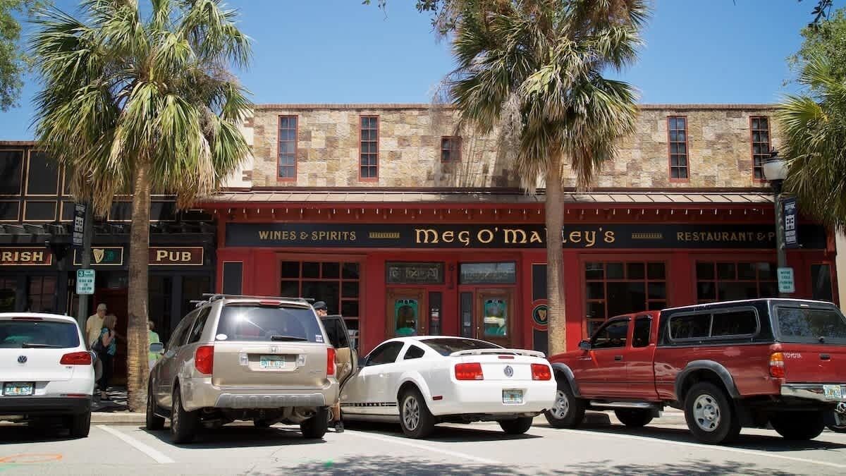 Un bâtiment sur lequel on peut lire une enseigne indiquant « Restaurant et bar de Megan » et, au-dessus, une autre enseigne indiquant « Vins et spiritueux ».