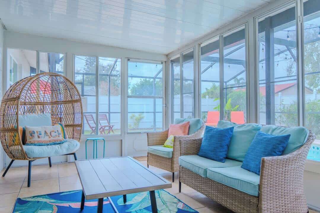 A sunroom with wicker furniture, a glass ceiling, and a view of the outside.