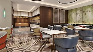Ein modernes Restaurant-Interieur mit einem gemusterten Boden, runden Deckenleuchten und einer Bar im Hintergrund.
