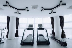 A gym with two treadmills, a rowing machine, and a stationary bike. - Jinjiang Metropolo Hotel Nanjing Jiangning Binjiang Development Zone Hotel (Nanjing)