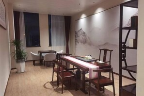 Un comedor con una mesa larga, sillas y una planta en maceta.