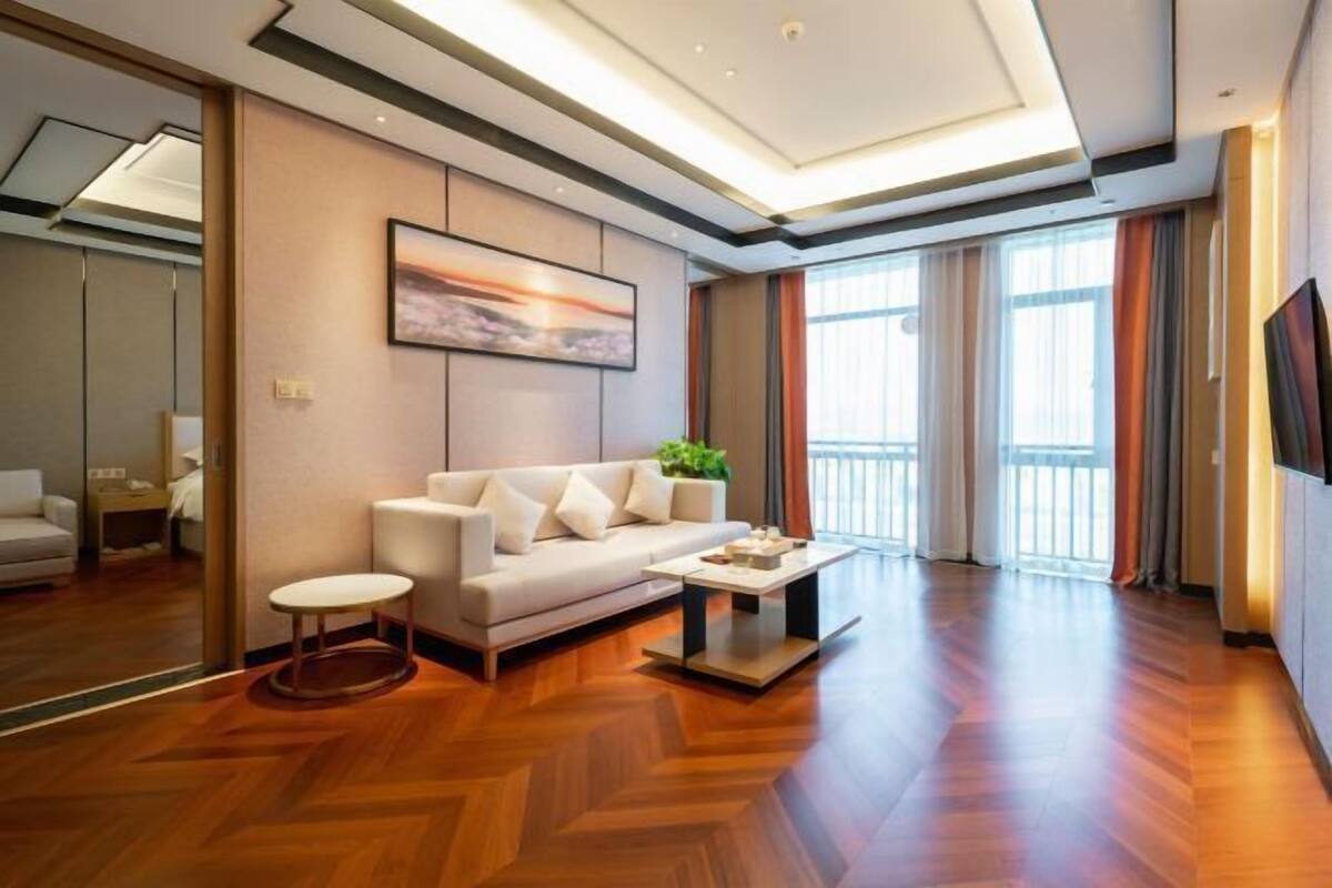 A modern living room with a sofa, coffee table, and a painting on the wall.