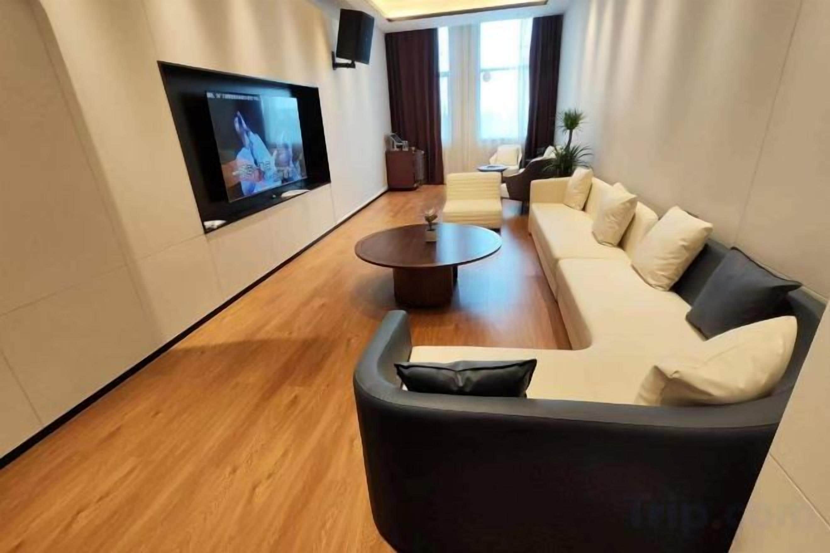 Una sala de estar moderna con un sofá curvo, una mesa de centro y un televisor de pantalla plana montado en la pared.