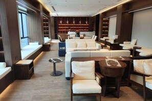 A modern hotel lobby with seating areas, a reception desk, and a fireplace. - Mingcheng Xincheng Hotel (Sanming)