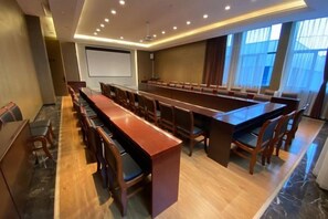 A conference room with a long table, chairs, a projector screen, and a large window. - Mingcheng Xincheng Hotel (Sanming)