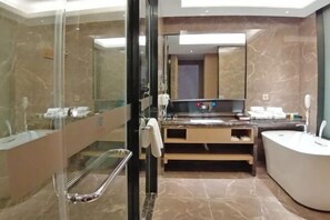 A modern bathroom with a glass shower enclosure, a large mirror, a vanity with a sink, and a freestanding bathtub.
