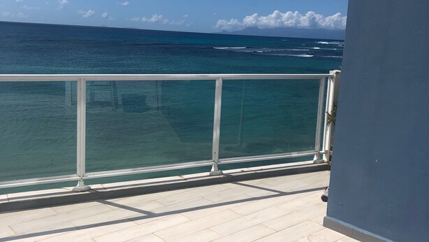 A balcony with a view of the ocean and a clear sky. - Appartement Duplex Bord de mer à Proximité de Tout ! (Saint-François)