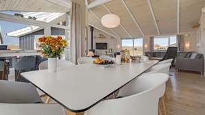 A spacious living area with a large white table, comfortable seating, and a view of the outdoors. - Cozy home in Haderslev with sauna (Haderslev)