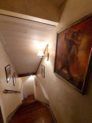 Una escalera con peldaños de madera y un accesorio de luz fijado a la pared.