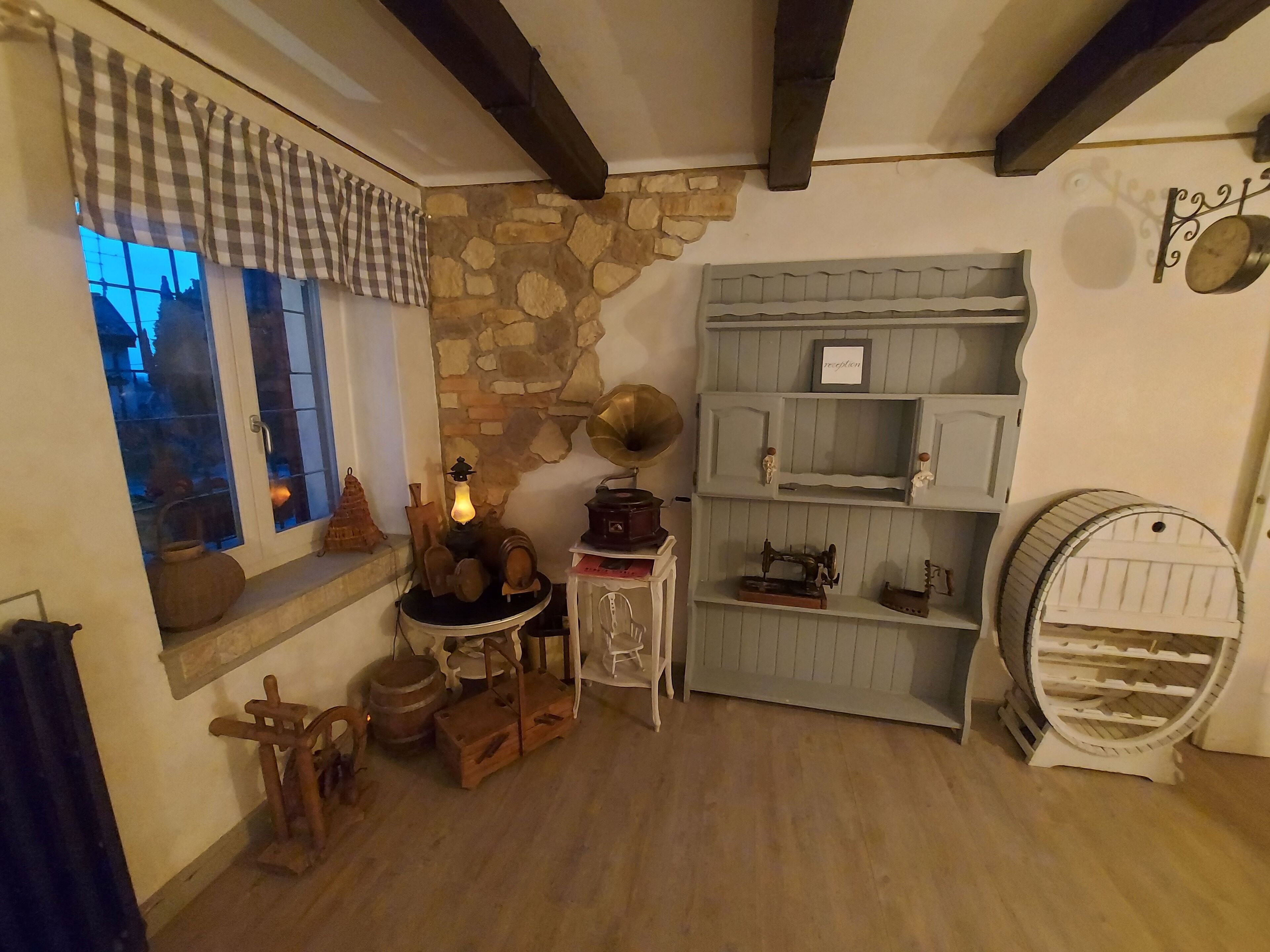 Een rustieke kamer met een stenen muur, houten meubels en retro decoratie.