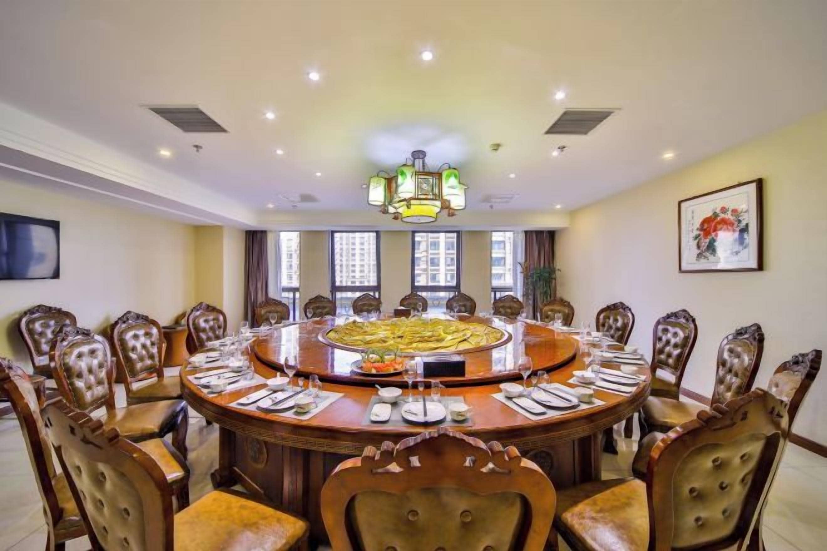 A conference room with a round table, chairs, and a chandelier.