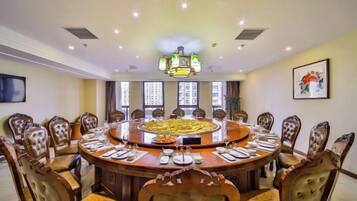A conference room with a round table, chairs, and a chandelier.