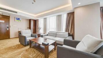 Une chambre d’hôtel moderne avec un canapé, un fauteuil et une petite table.