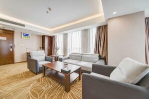 Ein modernes Hotelzimmer mit einer Couch, einem Sessel und einem kleinen Tisch.