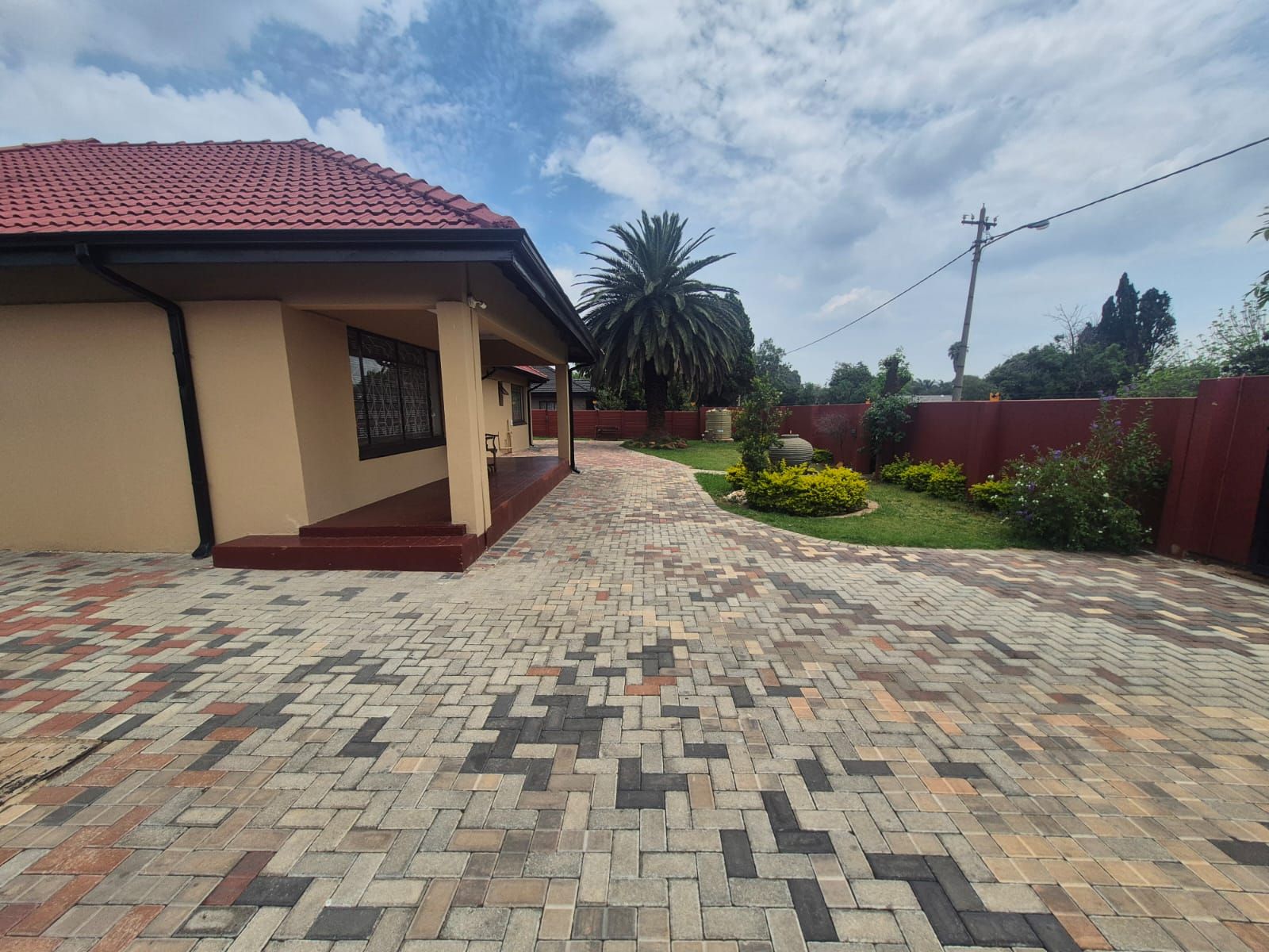 A house with a tiled driveway leading to a covered porch.