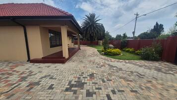 A house with a tiled driveway leading to a covered porch.