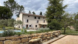 A two-story building with a pool and outdoor seating. - La Bastide des Oliviers (COTIGNAC)