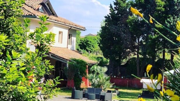 A swimming pool surrounded by greenery and a house with a tiled roof. - A True Sicilian guesthouse with Pool on Mt. Etna, perfect for Families & Groups. (Puntalazzo)