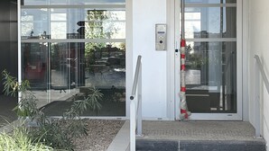 A building entrance with a glass door labeled "RESIDENCE PORT MARIA".