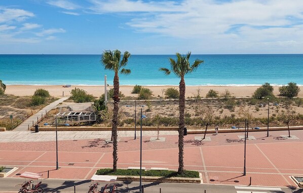 A beachside parking area with palm trees, a boardwalk, and a view of the ocean. - Stunning apartment in Peníscola with swimming pool (Peníscola)
