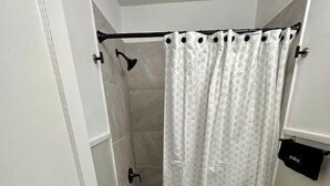 Ein kleines Badezimmer mit Dusche, Toilette und Waschbecken.