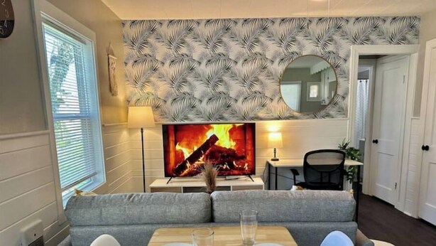 Ein gemütliches Wohnzimmer mit Kamin, einem Esstisch mit Stühlen und einer Couch.