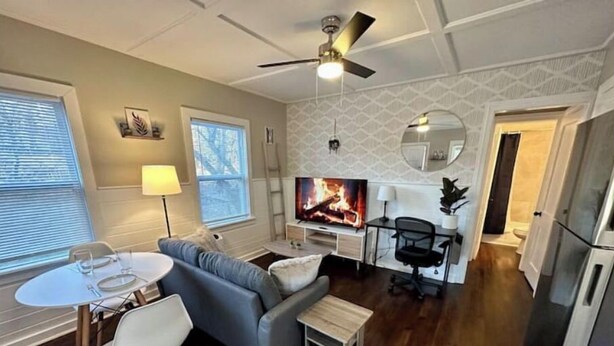 A modern living room with a fireplace, a dining area, and a kitchen. - The Red Door Cottage (Hendersonville)
