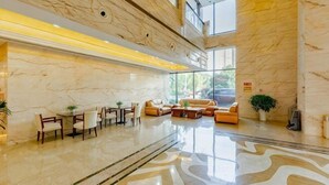 A spacious lobby with a marble floor, a seating area with sofas and chairs, and a large window providing natural light. - Danling Jinjiang Hotel (Danleng)