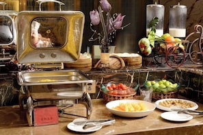 A buffet setup with various food items and a decorative mirror. - Danling Jinjiang Hotel (Danleng)