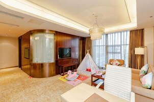 Habitación de hotel con pared curva, televisor de pantalla plana, sofá, una mesita y una estructura parecida a una tienda de campaña.