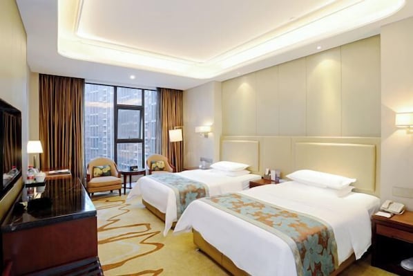 A hotel room with two beds, a desk, a chair, a TV, and a large window with curtains. - Danling Jinjiang Hotel (Danleng)