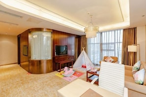 A hotel room with a curved wall, a television, a sofa, a lamp, and a tent-like structure.