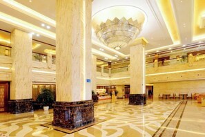 A spacious lobby with marble columns, a grand chandelier, and a patterned floor. - Danling Jinjiang Hotel (Danleng)
