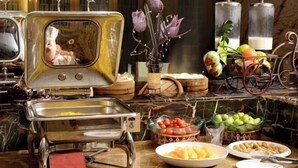 A buffet setup with various food items, a decorative mirror, and a vintage radio. - Danling Jinjiang Hotel (Danleng)
