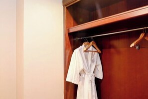 A wooden wardrobe with a robe hanging on a rod. - Danling Jinjiang Hotel (Danleng)