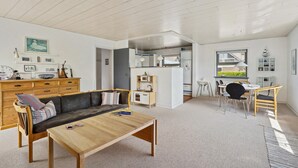 Un espacio habitable compacto con sofá, mesa de centro y comedor con sillas y mesa.