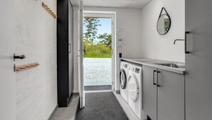 A laundry room with a washing machine, a sink, and a mirror on the wall. - Lovely home in Ulfborg with sauna (Ulfborg)