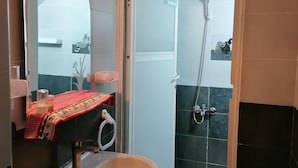 Un bany amb un lavabo, un mirall i una dutxa.