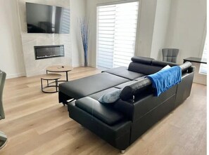 Relax in this stylish living room with a large sofa, coffee table, and flat-screen TV.