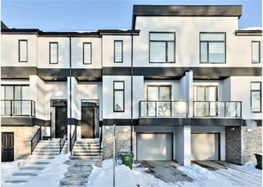 Stylish residential building with a central entrance and balconies on upper floors.