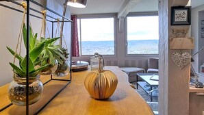 A cozy room with a wooden table, a large window with a view, and a decorative heart hanging on the wall. - Beautiful apartment in Tourgéville with WiFi (Tourgéville)