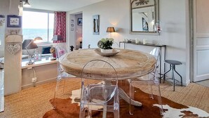 A round dining table with a wooden top and clear glass legs, surrounded by a cowhide rug. - Beautiful apartment in Tourgéville with WiFi (Tourgéville)