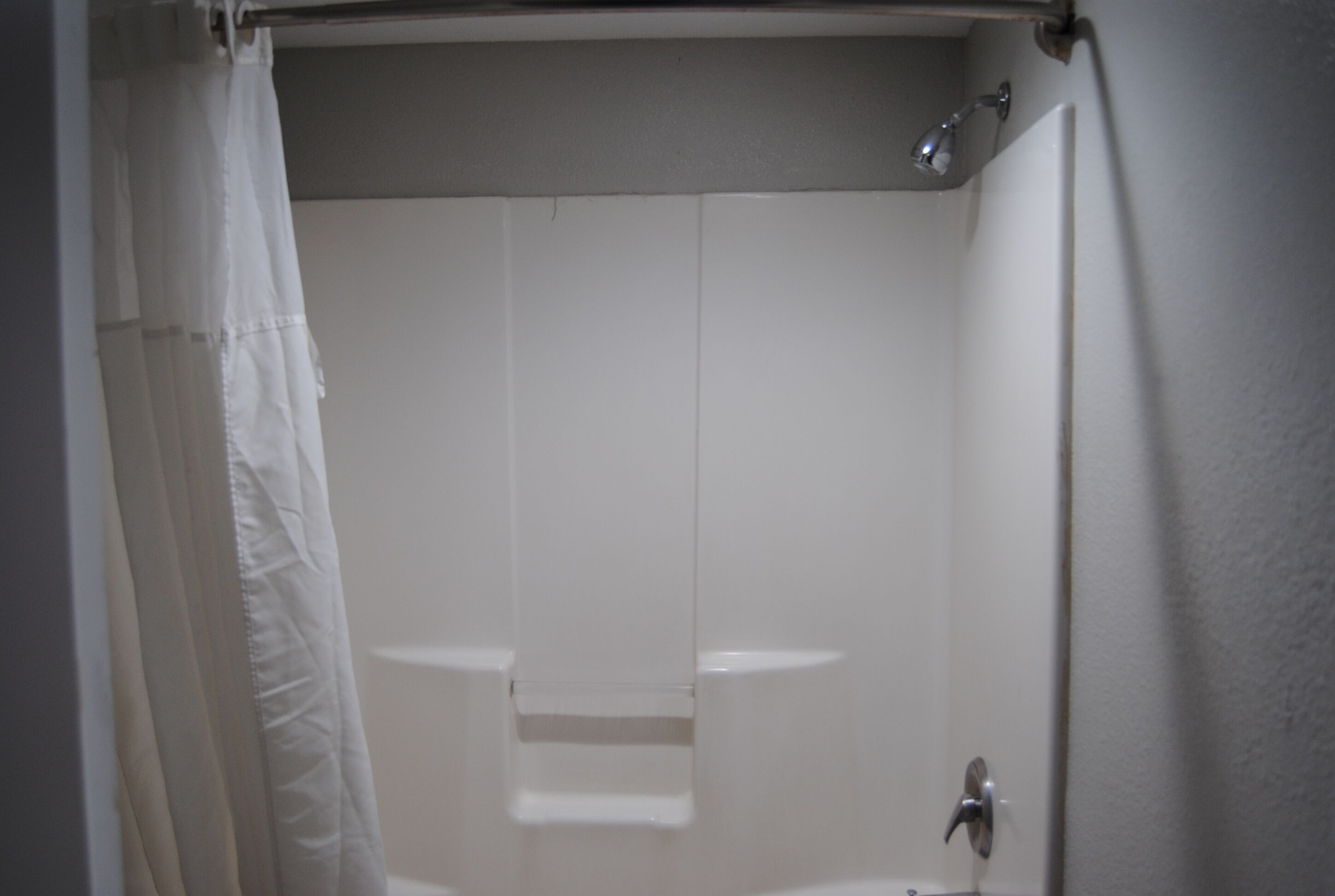 Et badeværelse med bruser, toilet og vask.