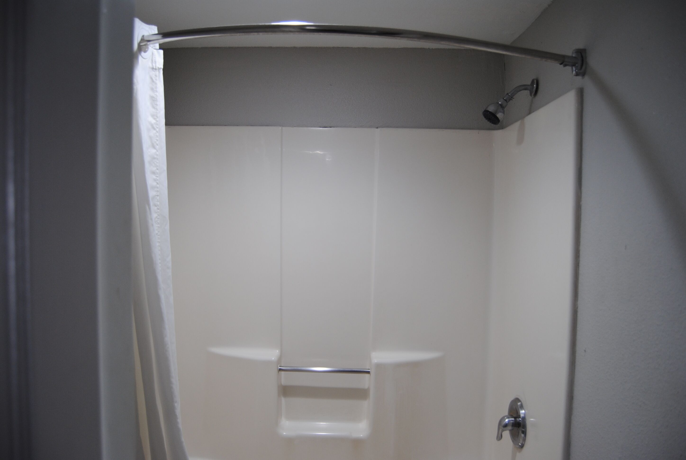 A bathroom with a shower, a toilet, and a sink.