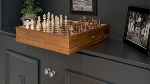 A chessboard on a wooden tray, a framed photograph, and a book titled "Annapolis Reflections" on a dark shelf. - Walk to the Naval Academy and Historic Annapolis.  Private parking at the home. (Annapolis)