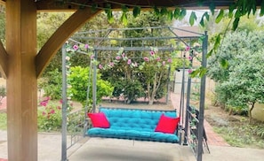 Ein überdachter Außenbereich mit Schaukelstuhl und einer Pergola.