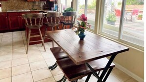Een keuken met houten kastjes, een granieten aanrecht en een eettafel met vier stoelen.