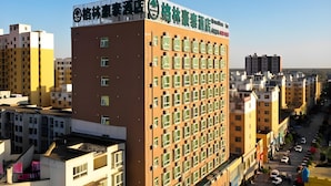 A hotel with a modern design, featuring a prominent sign at the top and multiple windows on the facade.